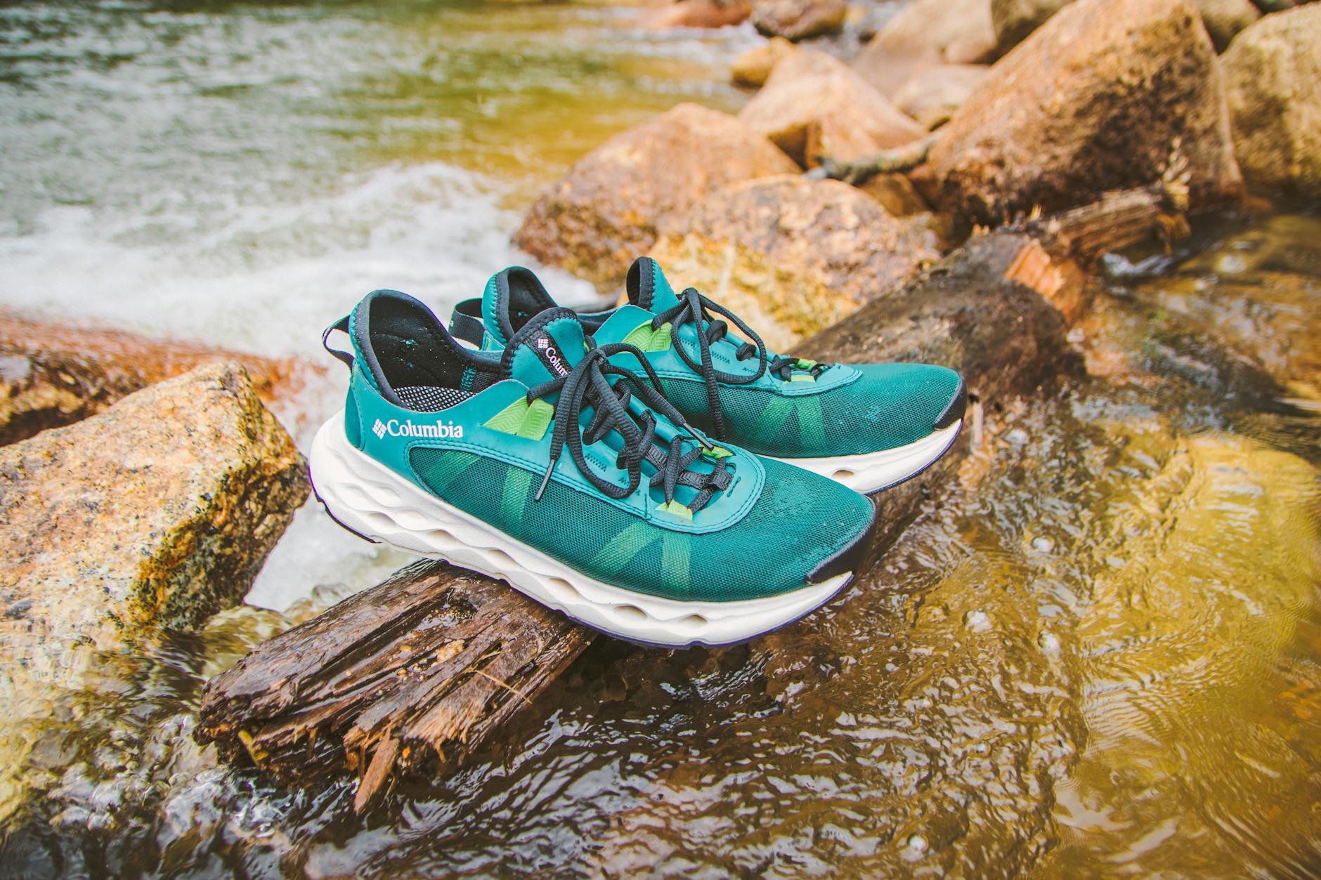 Teal hiking shoes on a log over a river in Đ&agrave; Lạt, perfect for adventure and outdoor enthusiasts.