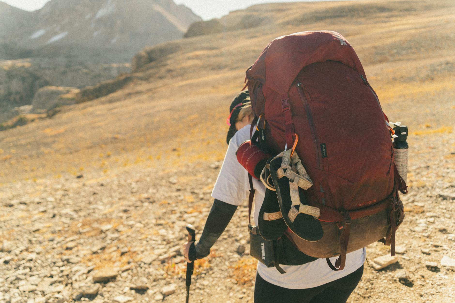 Backpacker with gear on Teton Crest Trail in Wyoming's wilderness.